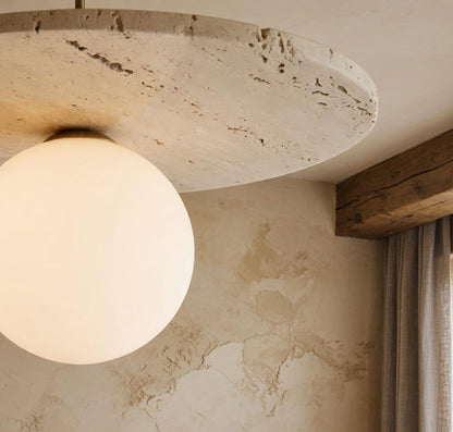 Suspension marbre Wabi-Sabi avec globe opalin sous disque en travertin, intérieur mur chaux et poutre bois
