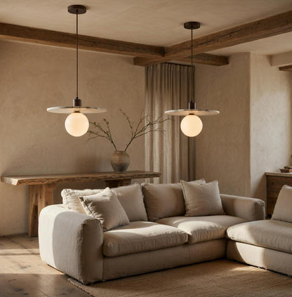 Paire de suspensions marbre et verre opalin au-dessus d'un canapé lin beige, décoration Wabi-Sabi
