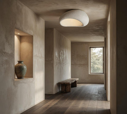 Plafonnier galet Wabi-Sabi blanc dans couloir mur en chaux, niche avec vase en céramique